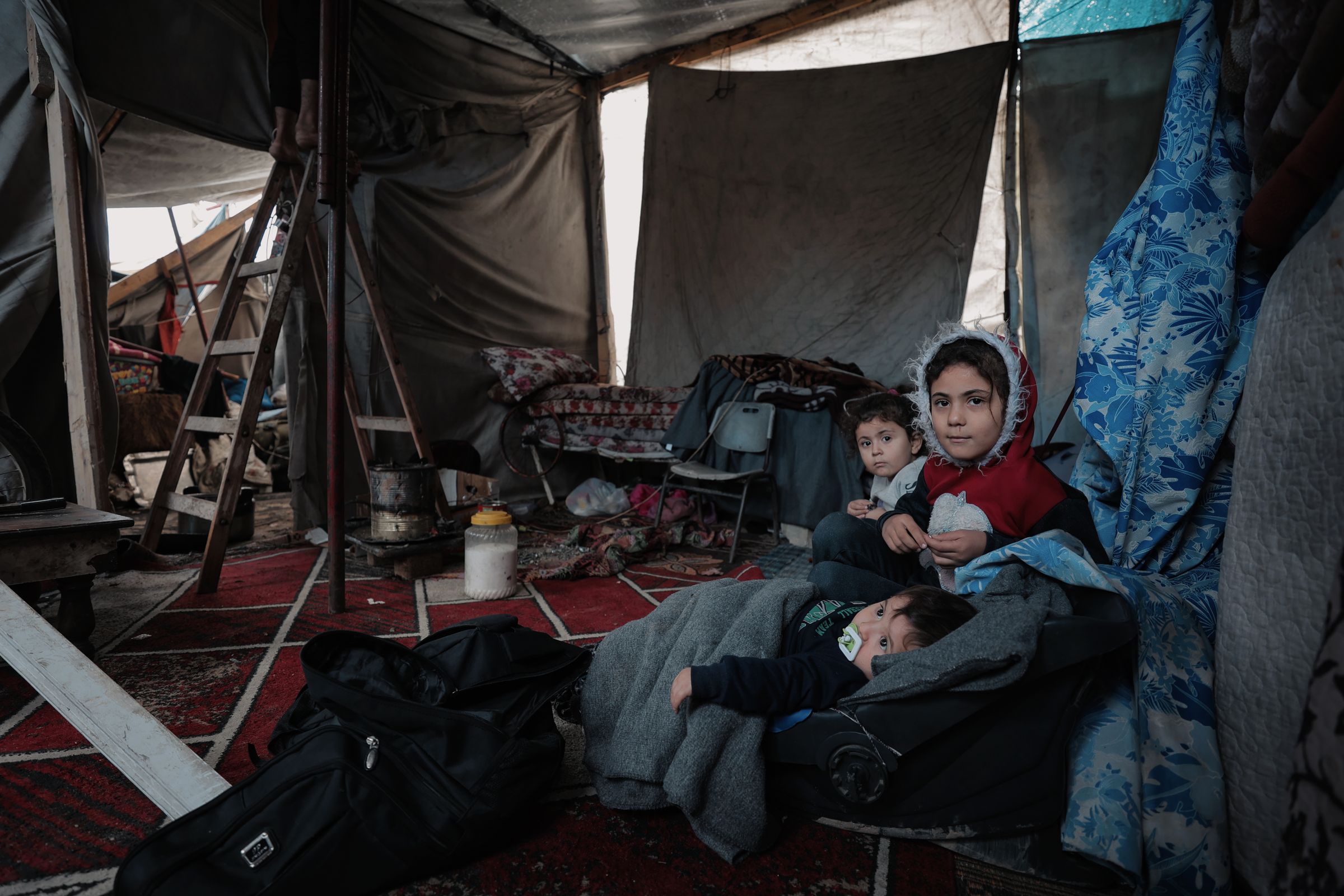 Child in a displacement camp in Gaza holding a small plush toy